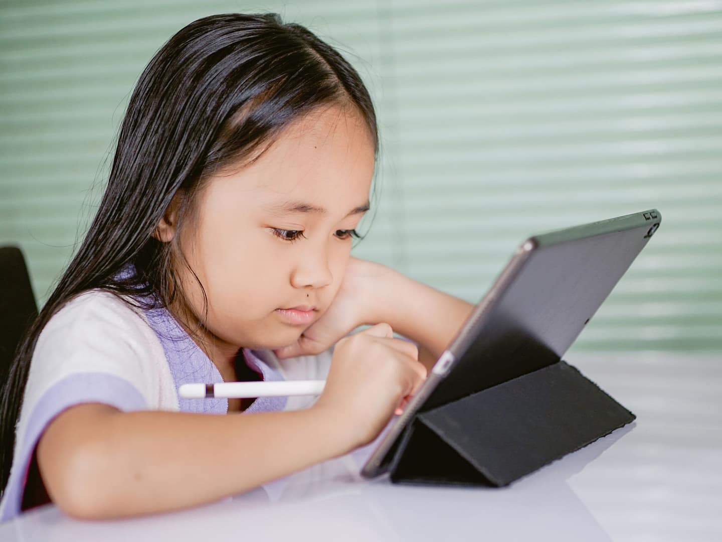 Young girl using a tablet for online learning at home