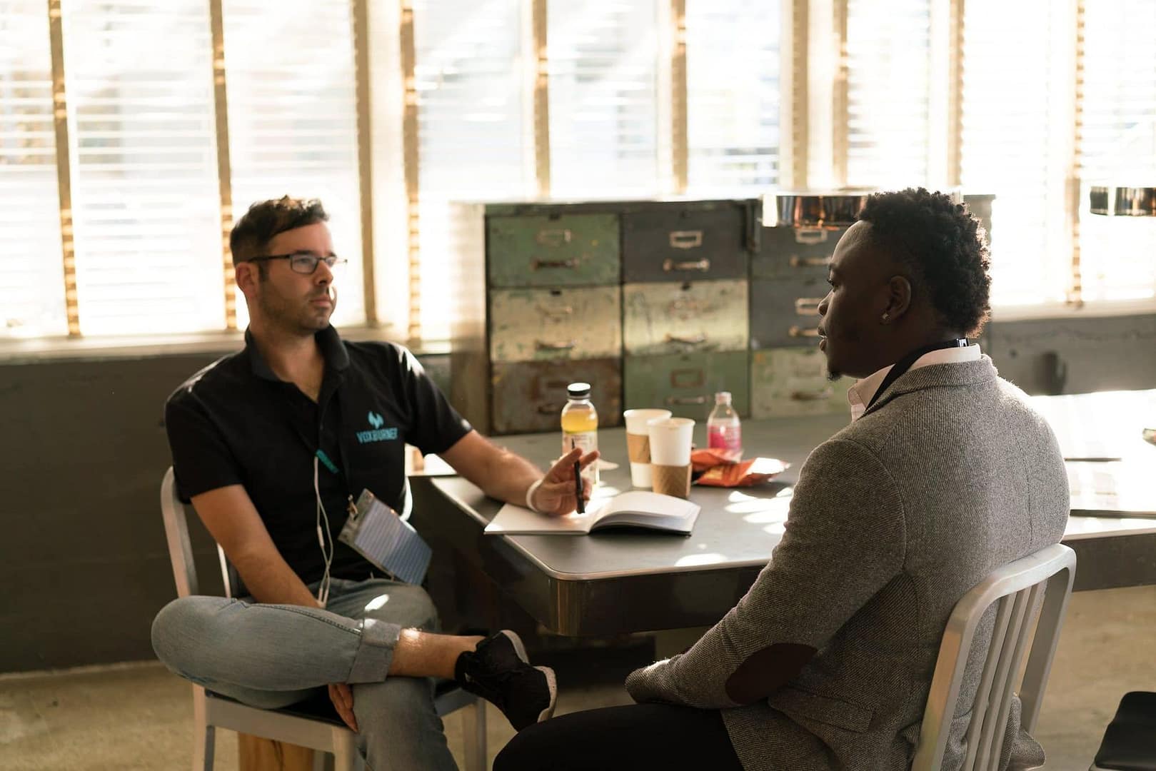 Two men in a focused coaching conversation in a bright office