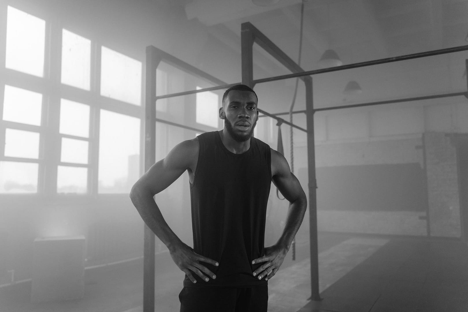 Focused athlete standing in a gym in black and white