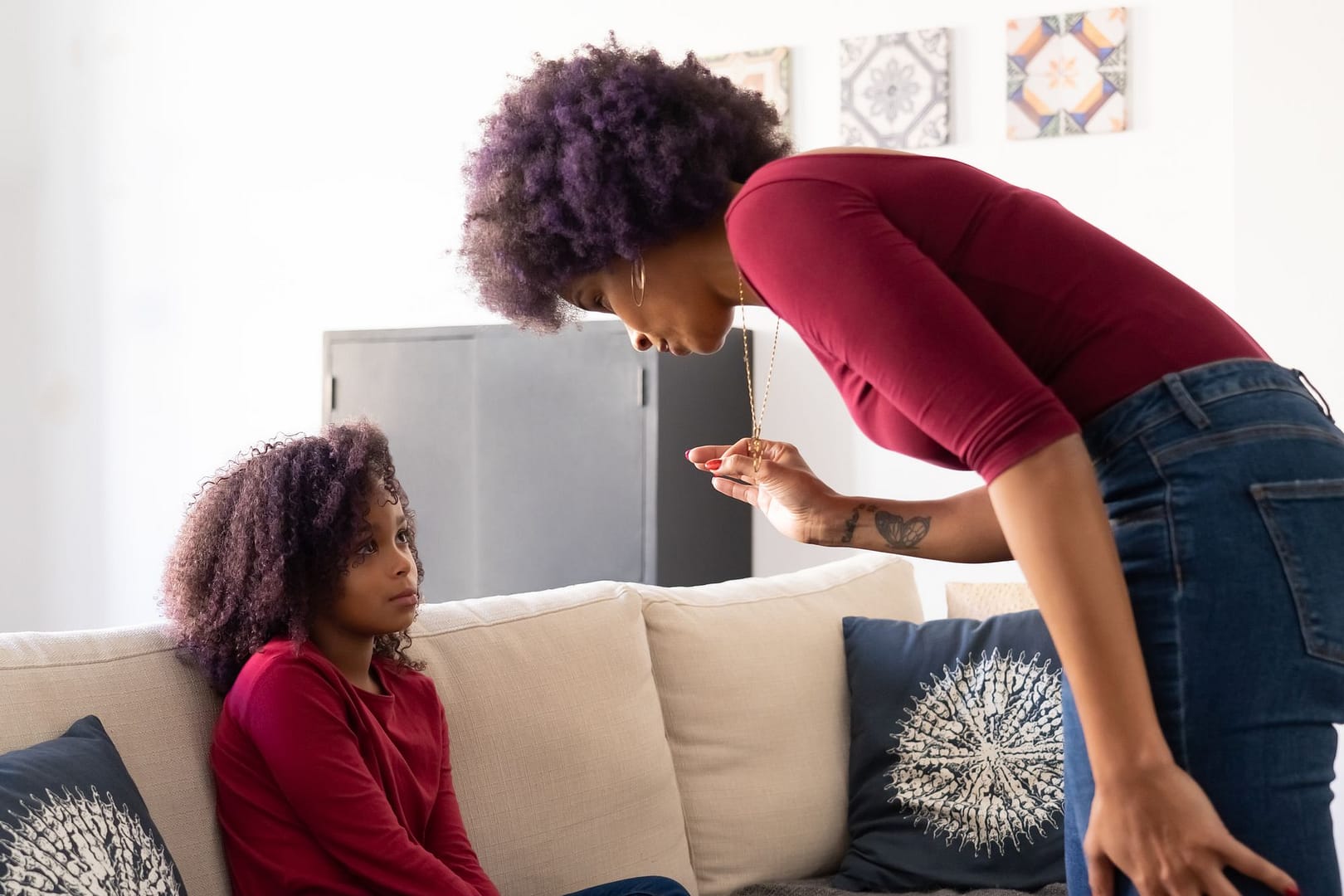 Mother and daughter having a serious conversation on a sofa at home