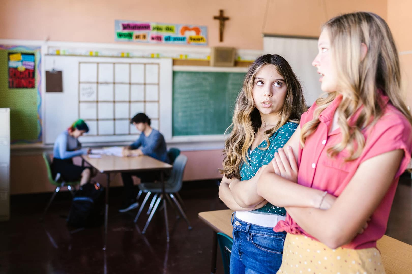Teenage girls having a conversation in a classroom
