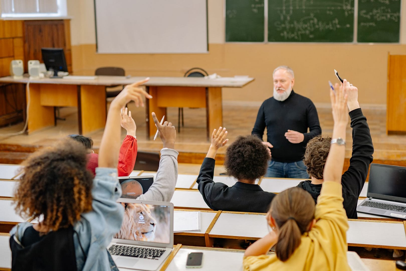 Students raising their hands in a classroom